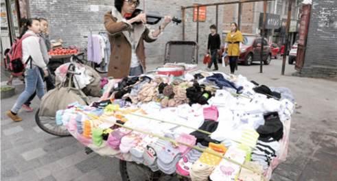 拉小提琴卖袜子的“80后”练摊者师志雄。记者黄鹏摄